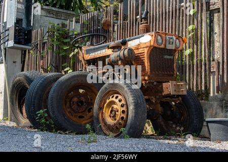 HUA HIN, THAILAND, MÄRZ 15 2022, der beschädigte alte Kubota-Traktor parkte neben dem Zaun. Stockfoto