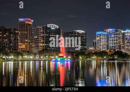 Nachtfoto am Lake Eola in Orlando mit dem farbenfrohen Brunnen und den reflektierten Gebäuden Stockfoto