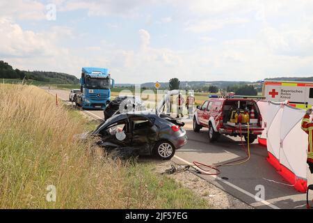 29. Juni 2022, Bayern, Unterknöringen: Feuerwehr- und Rettungskräfte arbeiten am Unfallort. Eine 87-jährige Fahrerin ist am Mittwoch bei einem Unfall in Burgau (Landkreis Günzburg) ums Leben gekommen. Sie wollte bei Unterknöringen in die Staatsstraße 2024 einbiegen und habe ein Auto von links übersehen, teilte die Polizei mit. (To dpa: 'Unfall beim Drehen - 87-jährige Fahrerin stirbt') Foto: Mario Obeser/dpa - ACHTUNG: Kennzeichen(e) wurden aus rechtlichen Gründen verpixelt Stockfoto