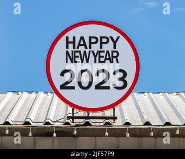 Eine Circle Plakatwand mit Text Happy New Year 2023, ist auf einem Dach installiert. Gruß zum neuen Jahr. Stockfoto