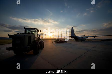 U.S. Airmen in einem Geländewagen 10K und einem Halvorsen 25K-Lader, der dem 621. Contingency Response Wing zugewiesen wurde, transiten zu einem C-130 Hercules, um Fracht in Osteuropa abzuladen, 21. April 2022. Die CRW 621. ist hochspezialisiert auf die Schulung und den schnellen Einsatz von Personal, um Flugplätze schnell zu öffnen und Flugmobilitätsoperationen einzurichten, zu erweitern, aufrechtzuerhalten und zu koordinieren. (USA Foto der Luftwaffe von Staff Sgt. Dennis Hoffman) Stockfoto