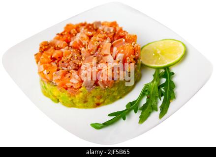 Lachstartare mit Guacamole auf dem Teller serviert Stockfoto