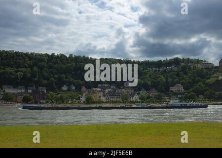 Lange und schmale Reederei Jaegers Flachbodenschiffe transportieren Güter durch den Mittelrhein, entlang St. Goar in Rheinland-Pfalz, Deutschland. Stockfoto