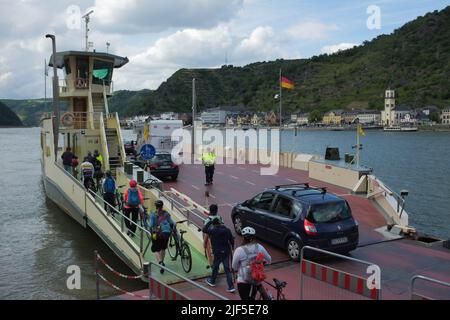 Deutsche laden mit ihren Fahrrädern und Autos auf eine Fähre, um den Rhein von St. Goar nach St. Goarshausen in Rheinland-Pfalz zu überqueren. Stockfoto