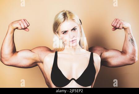 Lustiges Fitness-Paar. Funky Mädchen haben Bodybuilding Praxis, zeigen Bizeps. Eine junge weibliche Modell posiert mit männlichen großen Muskeln. Spaß an Fitness. Frauenmacht Stockfoto