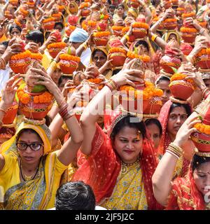 Neu Delhi, Indien April 03 2022 - Frauen mit Kalash am Kopf während des Jagannath-Tempels Mangal Kalash Yatra tragen indische Hindu-Anhänger irdische Töpfe Conta Stockfoto
