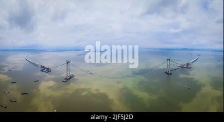 (220630) -- GUANGZHOU, 30. Juni 2022 (Xinhua) -- Luftfoto vom 7. Juni 2022 zeigt die Baustelle der Lingdingyang-Brücke, eines der Schlüsselprojekte der Shenzhen-Zhongshan-Autobahnverbindung, in der südchinesischen Provinz Guangdong. Die Gesamtlänge der Shenzhen-Zhongshan-Autobahnverbindung wird 24 Kilometer betragen und einen Unterwassertunnel und zwei künstliche Inseln umfassen. Die Verbindung wird 2024 für den Verkehr geöffnet. Mit dem Bau von Verkehrsadern wurde die Konnektivität in der Region Guangdong-Hong Kong-Macao Greater Bay kontinuierlich verbessert. Das bequeme Verkehrsnetz hat auch enha Stockfoto