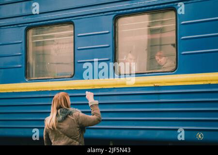 Lviv, Ukraine. 22. März 2022. Eine Mutter winkt mit der Hand zu ihrem Sohn, der gerade am Bahnhof von Lemberg angekommen ist. Der Bahnhof in Lemberg ist zu einem der wichtigsten Anlaufpunkte für die Flüchtlinge geworden, die dem Krieg aus dem Osten entkommen sind. (Foto: Lara Hauser/SOPA Images/Sipa USA) Quelle: SIPA USA/Alamy Live News Stockfoto