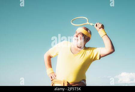 Älterer Mann, der Badminton spielt. Porträt eines gesunden Senioren-Sportmanns. Stockfoto