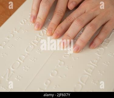 Eine Frau lernt das Braillealphabet mit einem Decoder. Stockfoto