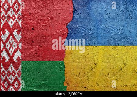 Weißrussland und die Ukraine - eine zerrissene Betonwand, die mit einer belarussischen Flagge auf der linken Seite und einer ukrainischen Flagge auf der rechten Seite bemalt ist Stockfoto