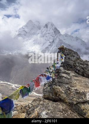 AMA Dablam umhüllt im Mai Wolken über dem Imja Khola vom Nangkartshang Peak (5073m), mit Gebetsfahnen über Dingboche geschmückt. Stockfoto