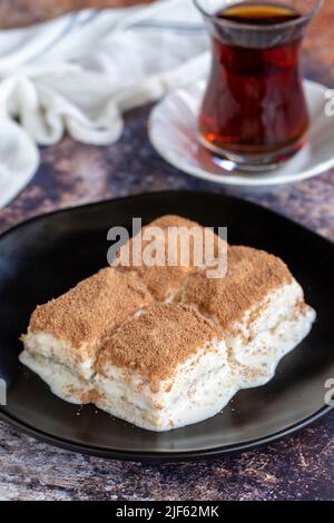 Kalte Baklava. Baklava mit Milch auf farbigem Hintergrund. Türkische Küche Delikatessen. Nahaufnahme Stockfoto