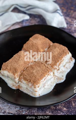 Kalte Baklava. Baklava mit Milch auf farbigem Hintergrund. Türkische Küche Delikatessen. Nahaufnahme Stockfoto