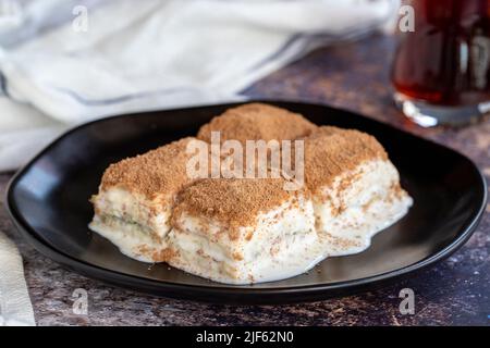 Kalte Baklava. Baklava mit Milch auf farbigem Hintergrund. Türkische Küche Delikatessen. Nahaufnahme Stockfoto