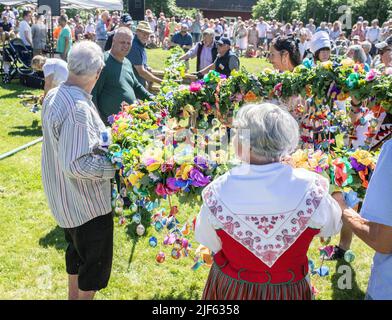 Die Leute bereiten sich vor, um den Mittsommerstab in malmkoping, Schweden, zu schmücken Stockfoto