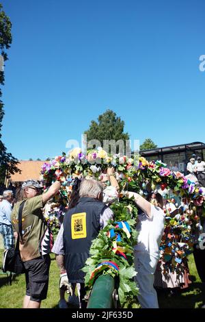 Die Leute bereiten sich vor, um den Mittsommerstab in malmkoping, Schweden, zu schmücken Stockfoto