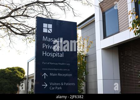 Schild vor dem Masada Private Hospital, Teil von Ramsay Health Care, mit Bäumen und Krankenhausgebäuden im Hintergrund Stockfoto