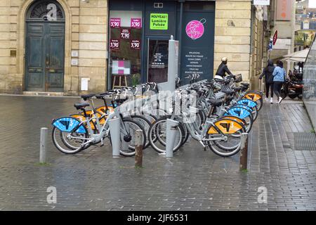 Elektrofahrräder stehen bereit zur Miete in der Rue Notre Dame, Bordeaux, Frankreich Stockfoto