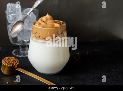 Dalgona Kaffee. Koreanischer Stil Kaffee-Eisgetränk auf dunklem Hintergrund. Instant-Kaffee mit Zucker und Wasser für ein leckeres Frühstück. Sehr modisch CO Stockfoto