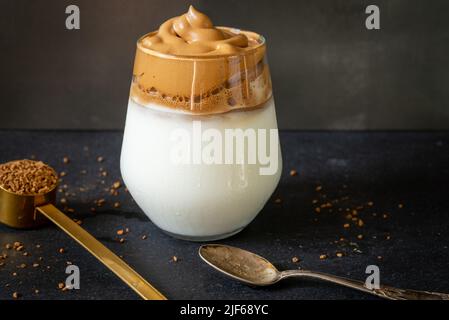 Dalgona Kaffee. Koreanischer Stil Kaffee-Eisgetränk auf dunklem Hintergrund. Instant-Kaffee mit Zucker und Wasser für ein leckeres Frühstück. Sehr modisch CO Stockfoto