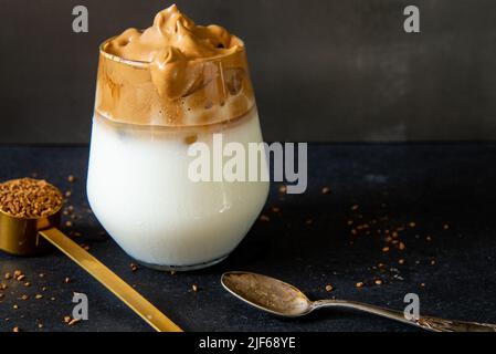 Dalgona Kaffee. Koreanischer Stil Kaffee-Eisgetränk auf dunklem Hintergrund. Instant-Kaffee mit Zucker und Wasser für ein leckeres Frühstück. Sehr modisch CO Stockfoto