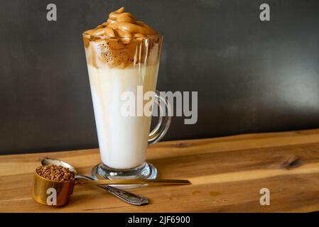 Dalgona Kaffee. Koreanischer Stil Kaffee-Eisgetränk auf dunklem Hintergrund. Instant-Kaffee mit Zucker und Wasser für ein leckeres Frühstück. Sehr modisch CO Stockfoto
