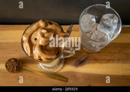 Dalgona Kaffee. Koreanischer Stil Kaffee-Eisgetränk auf dunklem Hintergrund. Instant-Kaffee mit Zucker und Wasser für ein leckeres Frühstück. Sehr modisch CO Stockfoto