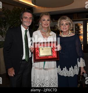 Mailand, Italien Barbara Bouchet erhält den Career Award der Mailänder Amici della Lirica Association übergibt die Plakette Attilio Fontana Präsident der Lombardei Region mit Daniela Javarone Präsidentin von AMAL am Abend das Buch von Maria Grazia Lamera mit dem Titel Amati tra ombre e luci edizioni LEROY von denen Bouchet Lesen Sie einige Sätze für Gäste, die beim Abendessen im Restaurant Ai Parioli anwesend sind, auf dem Foto: Barbara Bouchet erhält die Auszeichnung mit Attilio Fontana, dem Präsidenten der Region Lombardei, und Daniela Javarone, der Präsidentin von AMAL Stockfoto