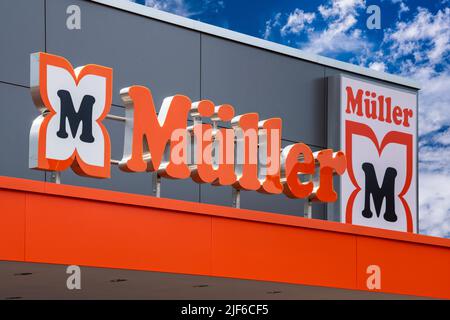 AUGSBURG, DEUTSCHLAND – 16. JUNI 2022: Werbeschild der Drogerie Müller vor einem wolkenbewölkten Himmel Stockfoto