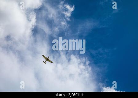 Ein alter Hawker-Ungehege aus der Zeit des Zweiten Weltkriegs, ein einsitziger Jagdflugzeug, der hoch oben am Himmel gegen Wolken über Billingshurst, West Sussex, Großbritannien, zu sehen ist. Stockfoto