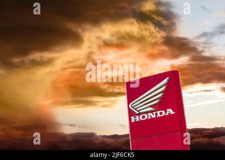 AUGSBURG, DEUTSCHLAND – 16. JUNI 2022: Werbeschild der Automarke HONDA vor einem wolkenbewölkten Himmel Stockfoto