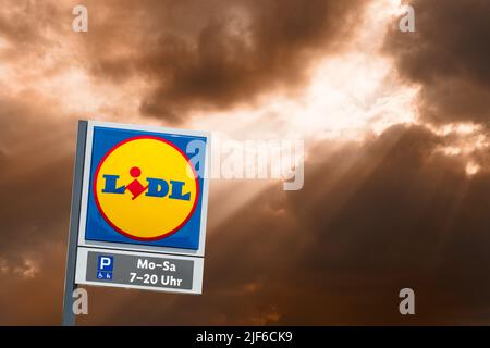 AUGSBURG, DEUTSCHLAND – 16. JUNI 2022: Werbeschild des Discounter-Stores LIDL vor einem wolkenbewölkten Himmel Stockfoto