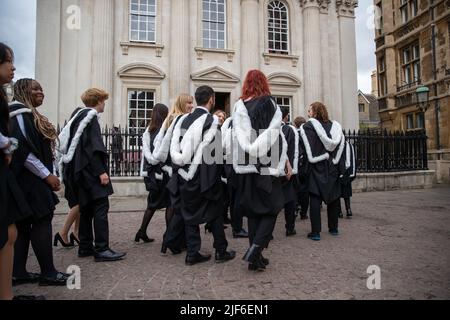 Bild vom 29.. Juni zeigt Studenten des King’s College Cambridge am Mittwochmorgen an ihrem Graduation Day, als die vollständigen Zeremonien nach covid Einschränkungen zurückkehren. Studenten in schwarzen Kleidern, als die traditionellen Abschlusszeremonien der Cambridge University heute (Mi) vor Familie und Freunden stattfanden – nachdem sie letztes Jahr wegen der Coronavirus-Pandemie auf Bildschirmen zusehen mussten. Die Studenten marschierten in das historische Senatshaus, um ihre Abschlüsse von der renommierten Universität zu sammeln. Familie und Freunde konnten sich die Zeremonie im Senatshaus ansehen, nachdem sie es geschafft hatten Stockfoto