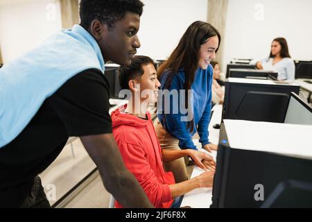 Multirassische Studenten mit Computern während der Business-Klasse in der Schule - Fokus auf asiatische Kerl Gesicht Stockfoto