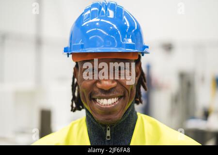 Afrikanischer Ingenieur, der in einer Roboterfabrik arbeitet - Fokus auf Gesicht Stockfoto
