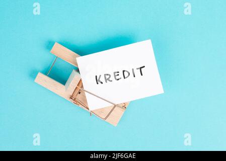 Papier mit dem Wort Kredit in deutscher Sprache in einer Mausefalle, Finanzverschuldung, Inflation, riskante Kredite und Investitionen, Bankkredit Stockfoto