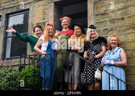 Haworth nostalgisches Retro-Ereignis mit Lebensgeschichte (Freunde, die Spaß in WW2 Replik-Vintage-Outfits haben, posieren) - Main Street, West Yorkshire, England, Großbritannien. Stockfoto