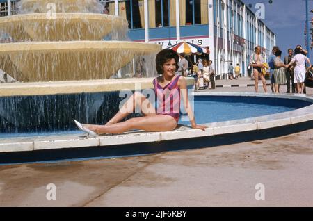 Eine junge Frau posiert in seinem Badekostüm am kaskadierenden Wasserbrunnen im Butlins Holiday Camp Minehead Juli 1962 Foto von Tony Henshaw Archive Stockfoto