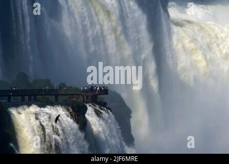 Touristen beobachten Teufelskehle von der brasilianischen Seite der Iguazu Wasserfälle an der Grenze zwischen Brasilien und Argentinien. Stockfoto