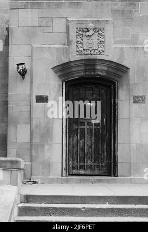 Vintage Holztür an einer alternden Steinwand in Schwarz und Weiß. Stockfoto