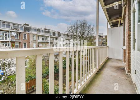 Kleiner gemauerter Balkon mit Metallgeländer und Tür Stockfoto