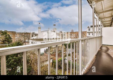 Kleiner gemauerter Balkon mit Metallgeländer und Tür Stockfoto