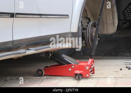 Hydraulischer Wagenheber, der den vorderen Teil des Autorads hebt Stockfoto