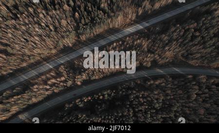 Kurve der Autobahn-Straße zwischen tiefen Wald in Ural, Russland. Schöne herbstliche Naturlandschaft bei tagsüber. Luftaufnahme von einer Drohne Stockfoto