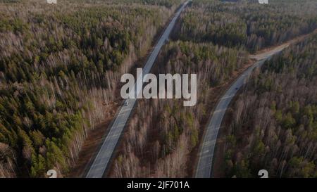 Kurve der Autobahn-Straße zwischen tiefen Wald in Ural, Russland. Schöne herbstliche Naturlandschaft bei tagsüber. Luftaufnahme von einer Drohne Stockfoto