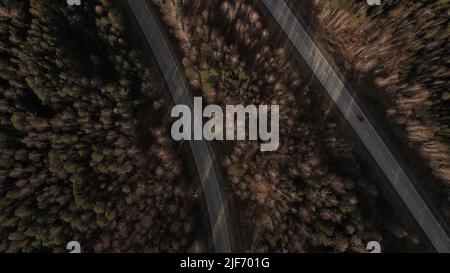 Kurve der Autobahn-Straße zwischen tiefen Wald in Ural, Russland. Schöne herbstliche Naturlandschaft bei tagsüber. Luftaufnahme von einer Drohne Stockfoto