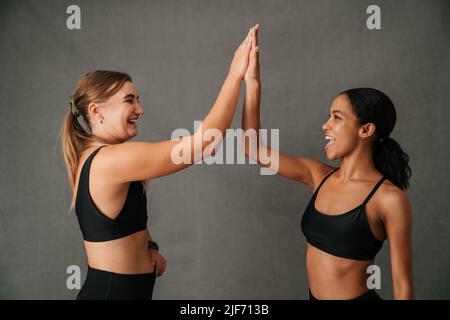 Zwei Freundinnen hallo fünf für das tolle Training im Fitnessstudio Stockfoto