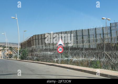 Der Sicherheitszaun an der marokkanischen Grenze wurde stark verstärkt, um Migranten an der Überquerung auf spanisches Territorium zu hindern. Nach dem massiven Versuch, die Grenze zwischen Marokko und Spanien zu überqueren, wurden die Stadt Nador und ihre Umgebung von der marokkanischen Polizei und Armee intensiv überwacht. Der Zaun wurde repariert und einige Todesfälle wurden schnell begraben. Die Belagerung durch die Sicherheitskräfte und die Angst vor Menschen, die unter irgendeiner Art von Repression leiden, erschweren den Erhalt von Informationen aus der Presse, wenn sie mit einigen Aussagen über das, was am 24. Juni 2 geschah, zusammenarbeiten Stockfoto