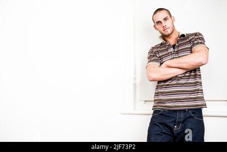 Lockeres Selbstvertrauen. Eine starke Haltung eines lässig gekleideten männlichen Models. Aus einer Reihe von Bildern mit den gleichen Modellen. Stockfoto
